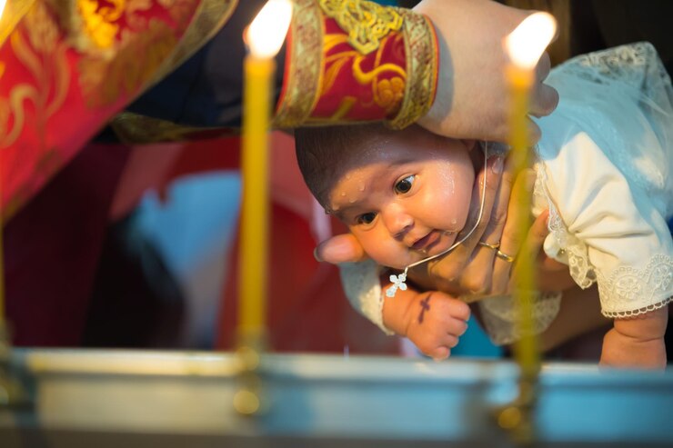 Baptism of a newborn childNewborn baby baptism by water with hands of priest
