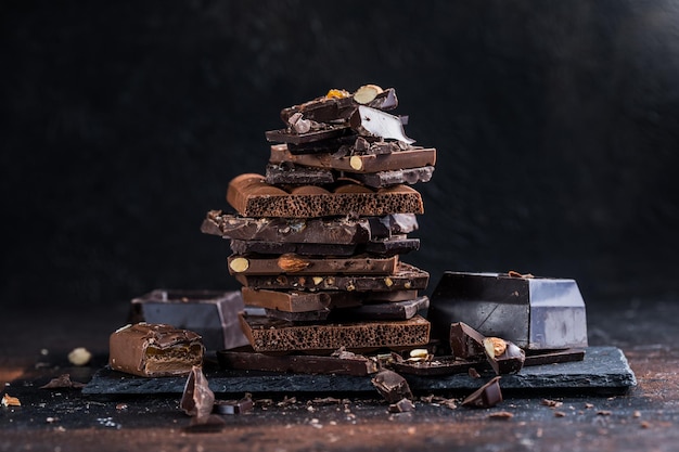 Bar of Chocolate tower pieces Hazelnut and almond dark chunks of broken chocolate Sweet food photo concept