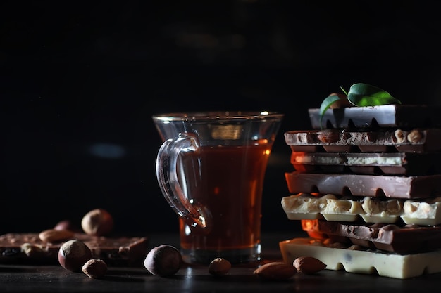 A bar of milk chocolate. Homemade milk chocolate with almonds and dried strawberries. Pieces of milk chocolate. Unlabeled milk chocolate bar.Set of chocolate with tea.