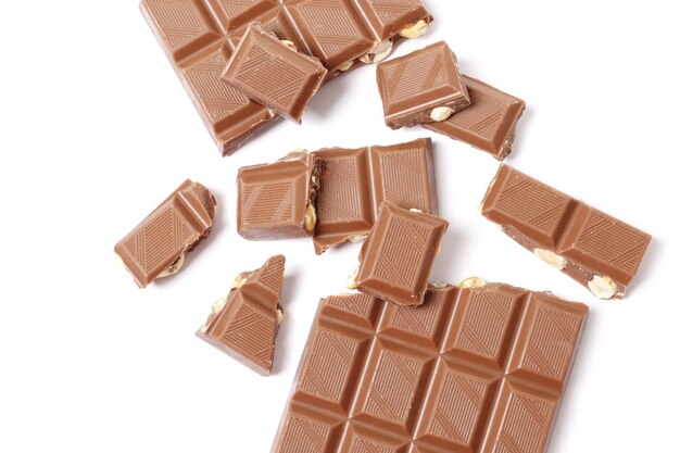 A bar and pieces of milk chocolate isolated on a white background. top view