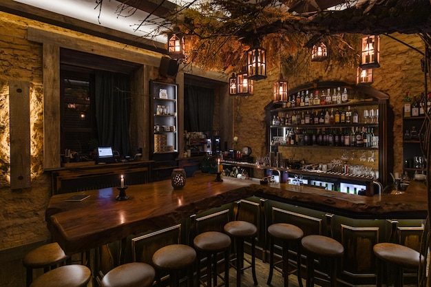 Bar with rustic counter and stools under decorative tree