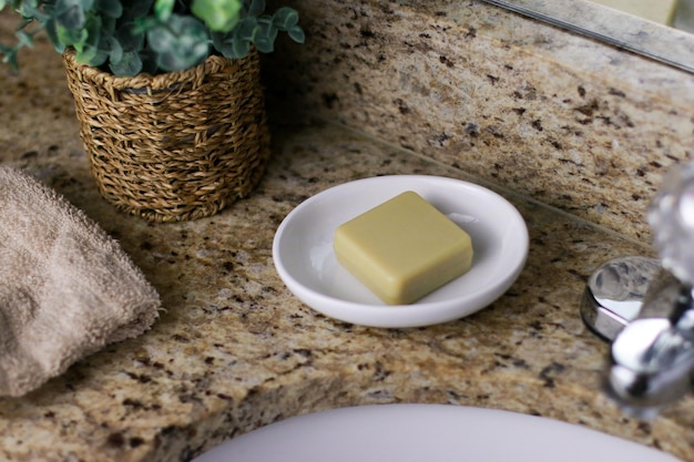 a bar of zero waste soap on white dish at bathroom sink