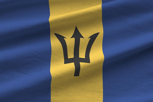 Barbados flag with big folds waving close up under the studio light indoors The official symbols and colors in banner