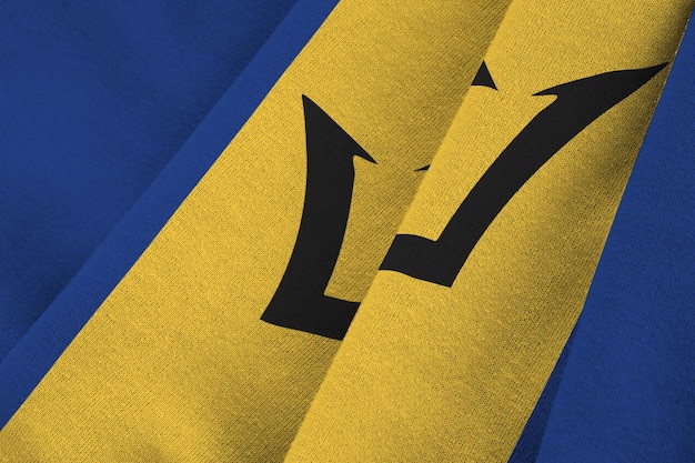 Barbados flag with big folds waving close up under the studio light indoors The official symbols and colors in banner