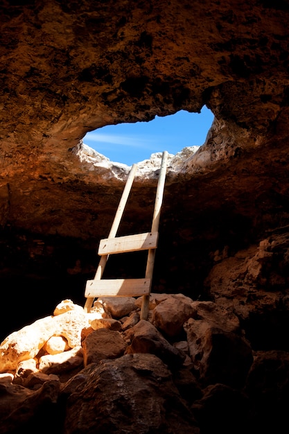 Barbaria cape cave hole met rustieke ladder op hout