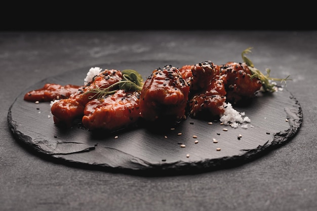 Barbecue chicken wings on a black stone