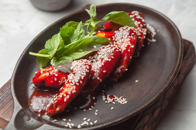 Barbecue chicken wings with sesame seeds and basilic Hot korean food Top view