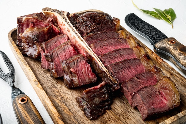 Barbecue droge leeftijd Wagyu Porterhouse Steak gesneden medium zeldzaam gekookt gemarmerd vlees set, op witte stenen achtergrond