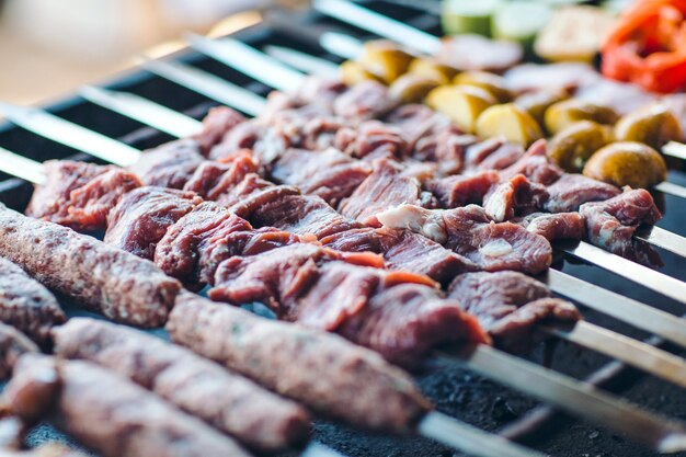 Barbecue from different types of meat in the restaurant on the background of the guests.