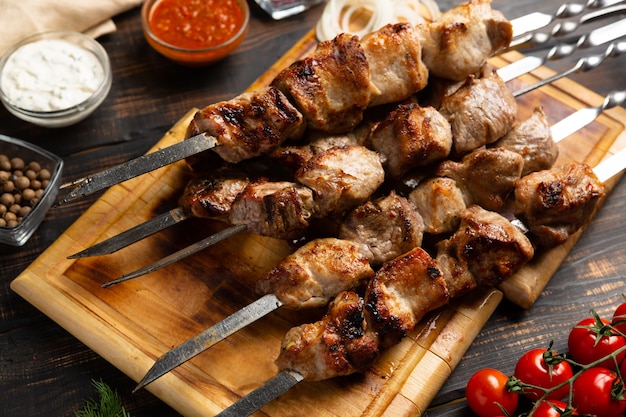 Barbecue Gegrild varkensvlees sjasliek kebab vlees op metalen spies op snijplank rustieke stijl