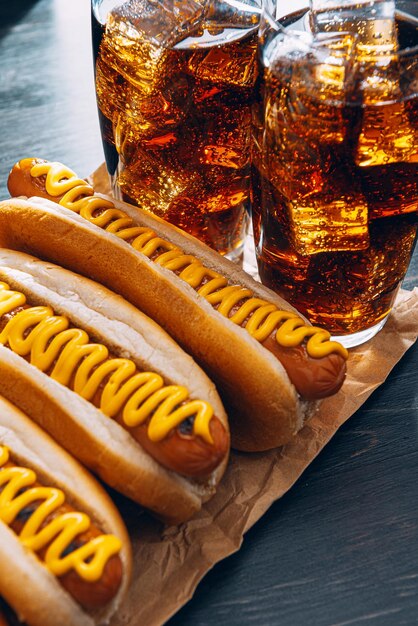 Barbecue gegrilde hotdogs met gele Amerikaanse mosterd, op een donkere houten ondergrond