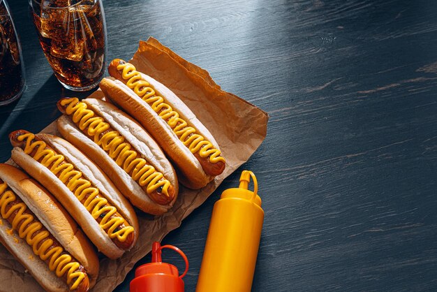 Barbecue gegrilde hotdogs met gele Amerikaanse mosterd, op een donkere houten ondergrond