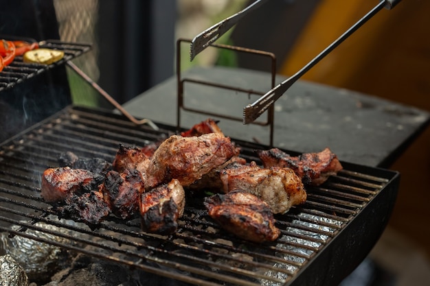 A barbecue grill with tasty juicy steaks are grilled over an open fire.