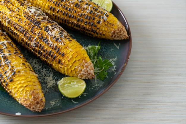 barbecue and grilled corn with cheese and lime on plate