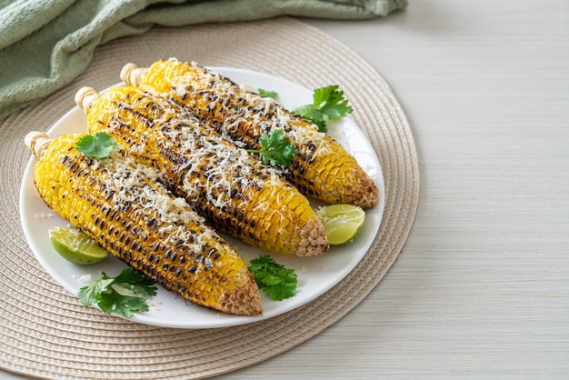 barbecue and grilled corn with cheese and lime on plate