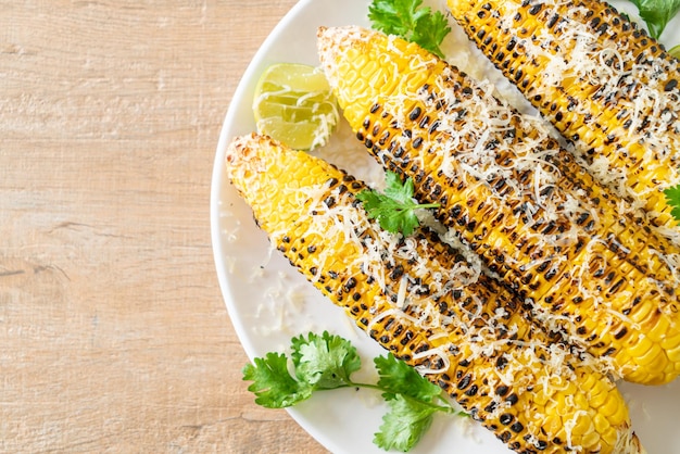 barbecue and grilled corn with cheese and lime on plate