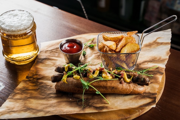 Barbecue grilled hot dog and beer with yellow mustard and ketchup 