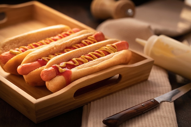 Barbecue grilled hot dog on wooden, dark style.