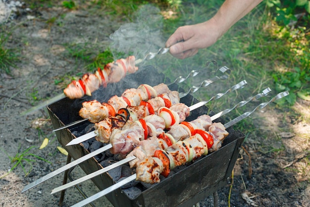 Barbecue koken met groenten op spijkers geroosterd vlees op de grill close-up