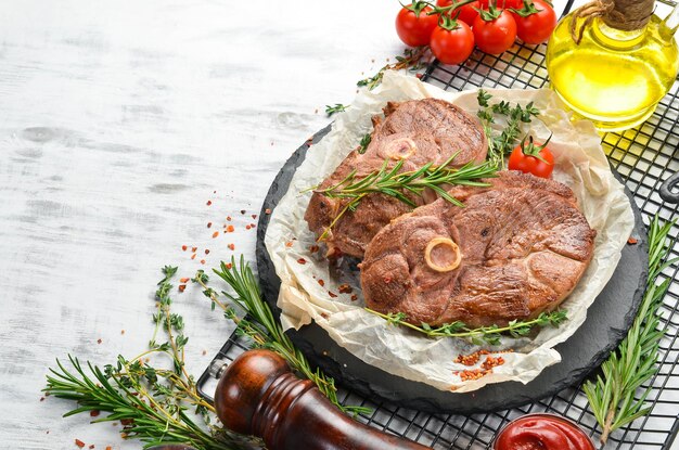 Barbecue. Lamslapje vlees met kruiden en groenten op een witte houten achtergrond. Plat leggen. Bovenaanzicht.