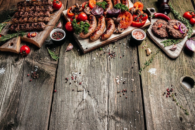 Barbecue menu Gegrild vleesassortiment van smakelijke bbq-snacks met groenten op houten plank banner menu recept plaats voor tekst bovenaanzicht