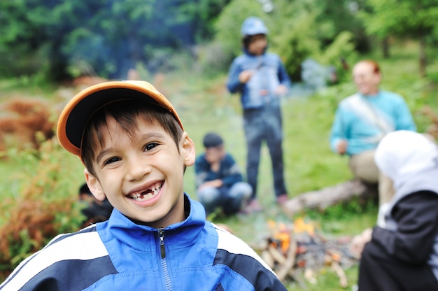 Barbecue in nature, group of children  preparing sausages on fire