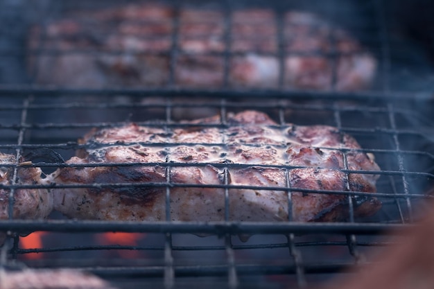 Barbecue op de grill wordt buiten gekookt Gegrild vlees op open vuur Varkenssteaks