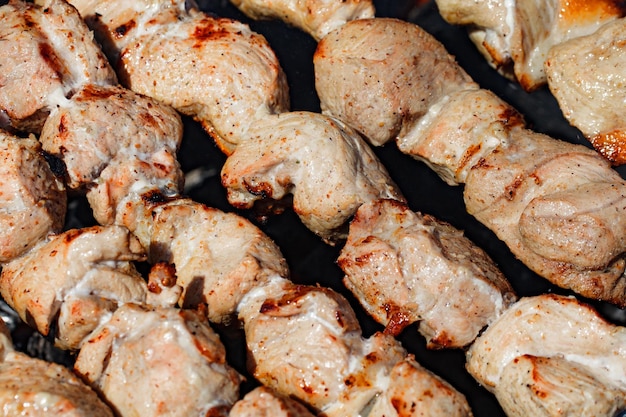 Barbecue pieces meat in the process of frying on the grill closeup selective focus