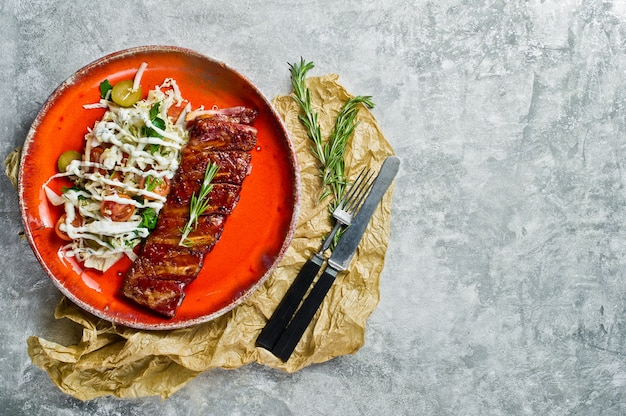 Barbecue pork ribs with a side dish of green salad. 