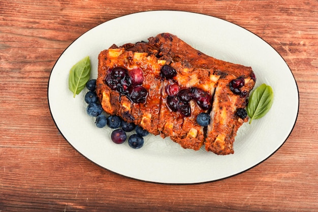 Barbecue pork spare loin ribs with blueberry sauce on old vintage wooden table