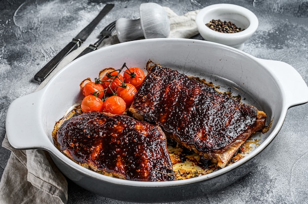 Barbecue pork spare ribs in a baking dish. Grilled meat.