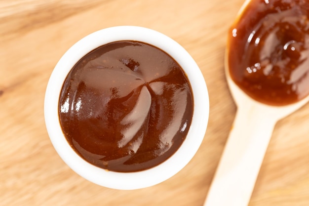 Barbecue sauce in bowl on wooden table still life