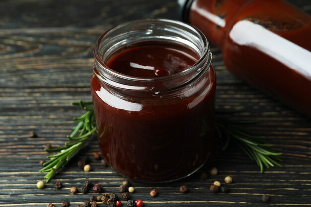 Barbecue sauce and spices on wooden table