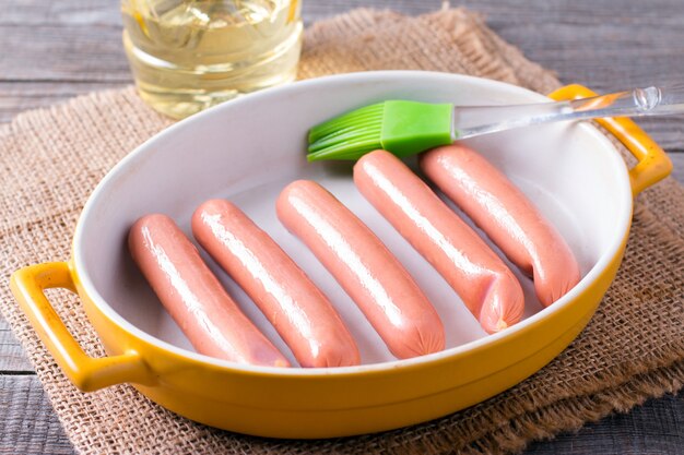 Barbecue sausages in frying pan on wooden table