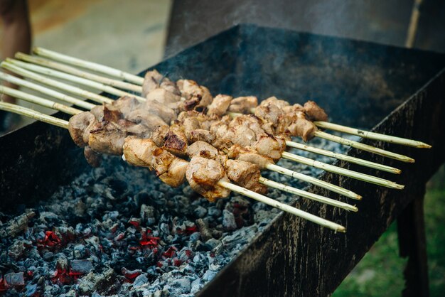 燃えるようなグリルのクローズアップでバーベキュー串に刺した牛肉のケバブ。