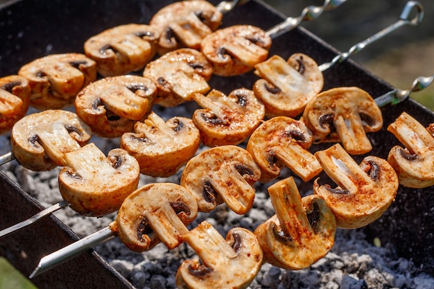 Spiedini di barbecue con delizioso kebab di funghi champignon alla griglia in un braciere