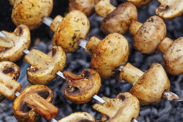 Barbecue spiesjes met gegrilde champignon champignon kebab in een vuurpot