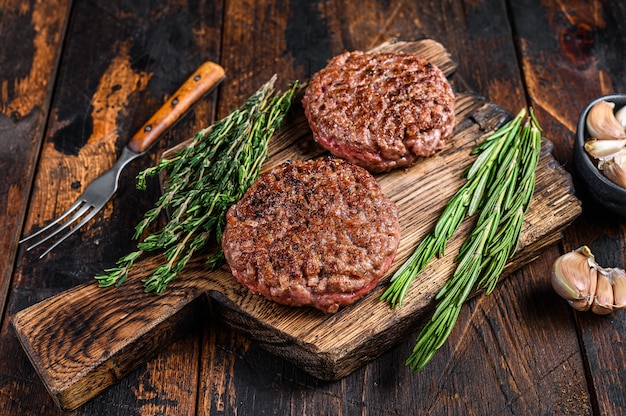 Barbecue steak pasteitjes voor hamburger van rundergehakt vlees op een houten snijplank