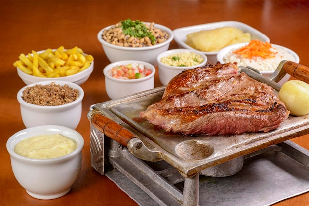 Barbecue steak roasted on the grill served with traditional Brazilian side dishes Churrasco