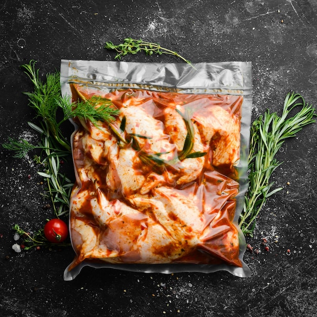 Barbecue Vacuum packaging with raw marinated chicken wings in chili sauce Top view Free space for your text