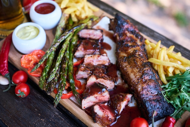 Barbecue varkensribbetjes op houten serveerplank op picknicktafel buiten