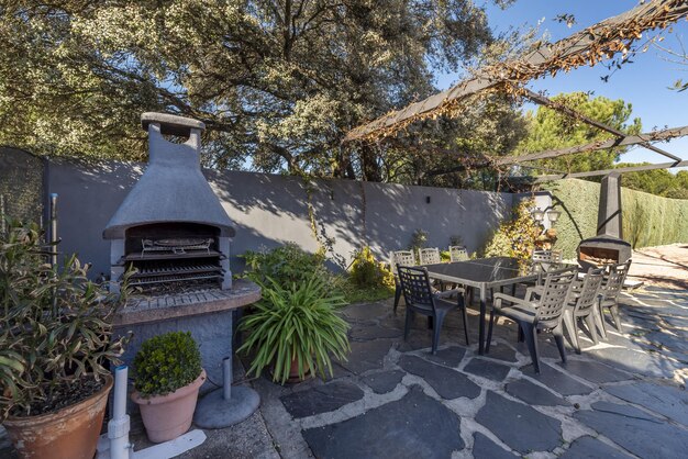 A barbecue with a fireplace in a garden with an outdoor dining area