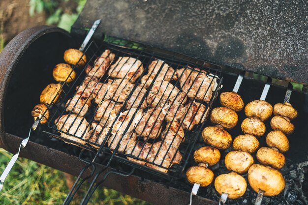 屋外のグリルで揚げた肉とキノコのバーベキュー、裏庭のキノコの串焼き