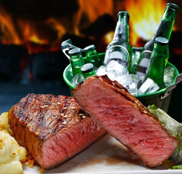 Barbecue con bistecca di carne e birra