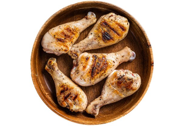 Barbecued Chicken leg drumstick poultry meat in a wooden plate Isolated on white background