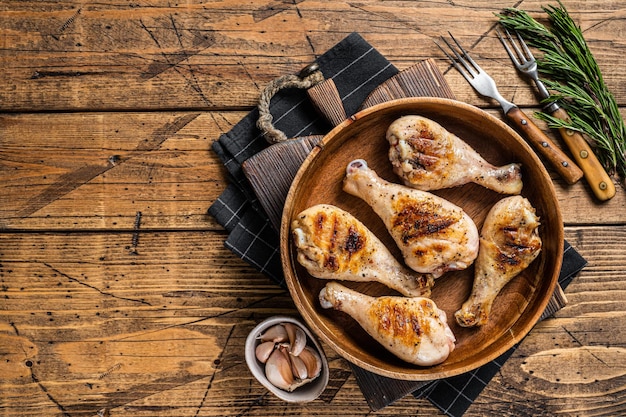 Carne di pollo con coscia di pollo alla brace in un piatto di legno sfondo in legno vista dall'alto spazio di copia