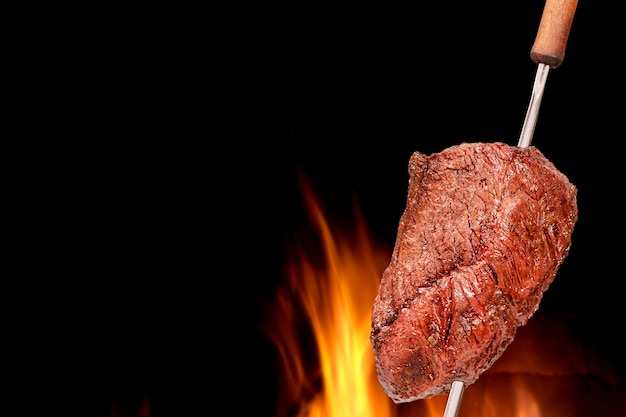 Barbecued Picanha barbecue with blurred fire in the background Also called churrasco