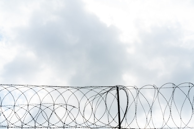 Barbed wire against cloud sky.