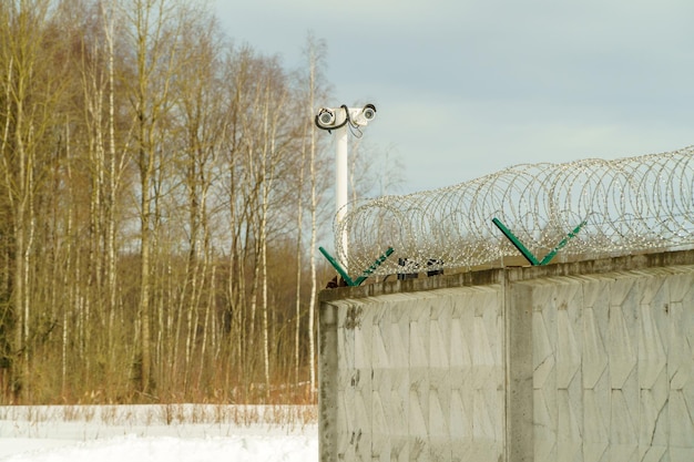 Barbed wire on the fence a fence made of steel grating spiral barbed wire on top of the perimeter