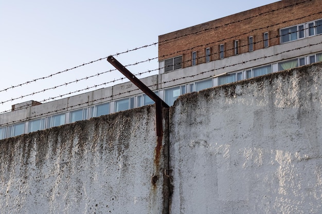 Barbed wire high concrete fence close up